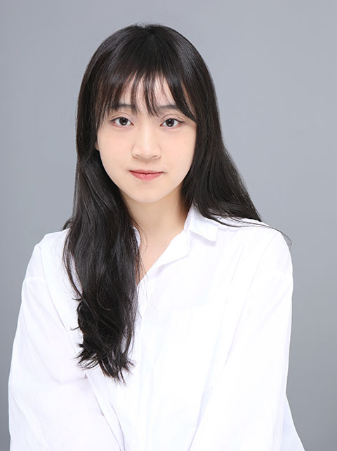 Doctoral Researcher image Eleanor Li, long dark hair with fringe wearing white shirt against a grey background
